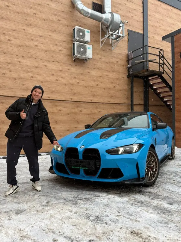 Синяя BMW M4 CS рядом с представителем Aura Cars